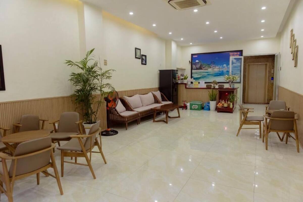 A hotel lobby with a reception desk, seating area, and a large painting on the wall.