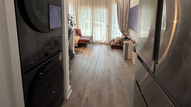 Una cocina moderna con horno empotrado, refrigerador y comedor con mesa y sillas.