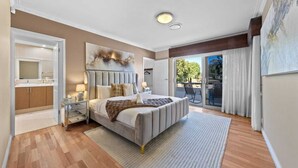 A bedroom with a bed, bedside tables, a nightstand, a large window, and a view of the outdoors. - 47 Ultimate Entertainer! Pool, Man Cave, Kids Play (Stirling)