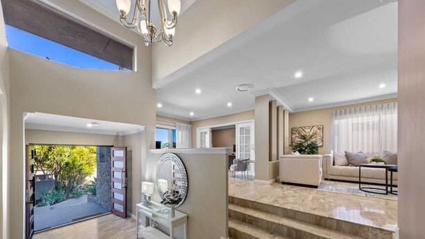 A spacious living area with a staircase, a large mirror, and a view of the outdoors. - 47 Ultimate Entertainer! Pool, Man Cave, Kids Play (Stirling)