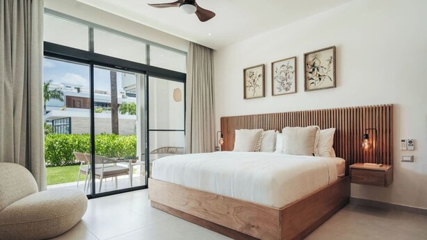 Una camera da letto moderna con un letto grande, un ventilatore a soffitto e vista sull'esterno.