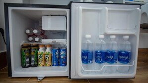 Geladeira aberta com bebidas e latas.