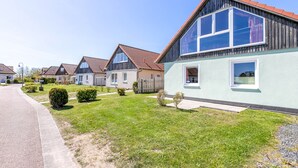 Una hilera de casas modernas con césped cuidado y entrada pavimentada.