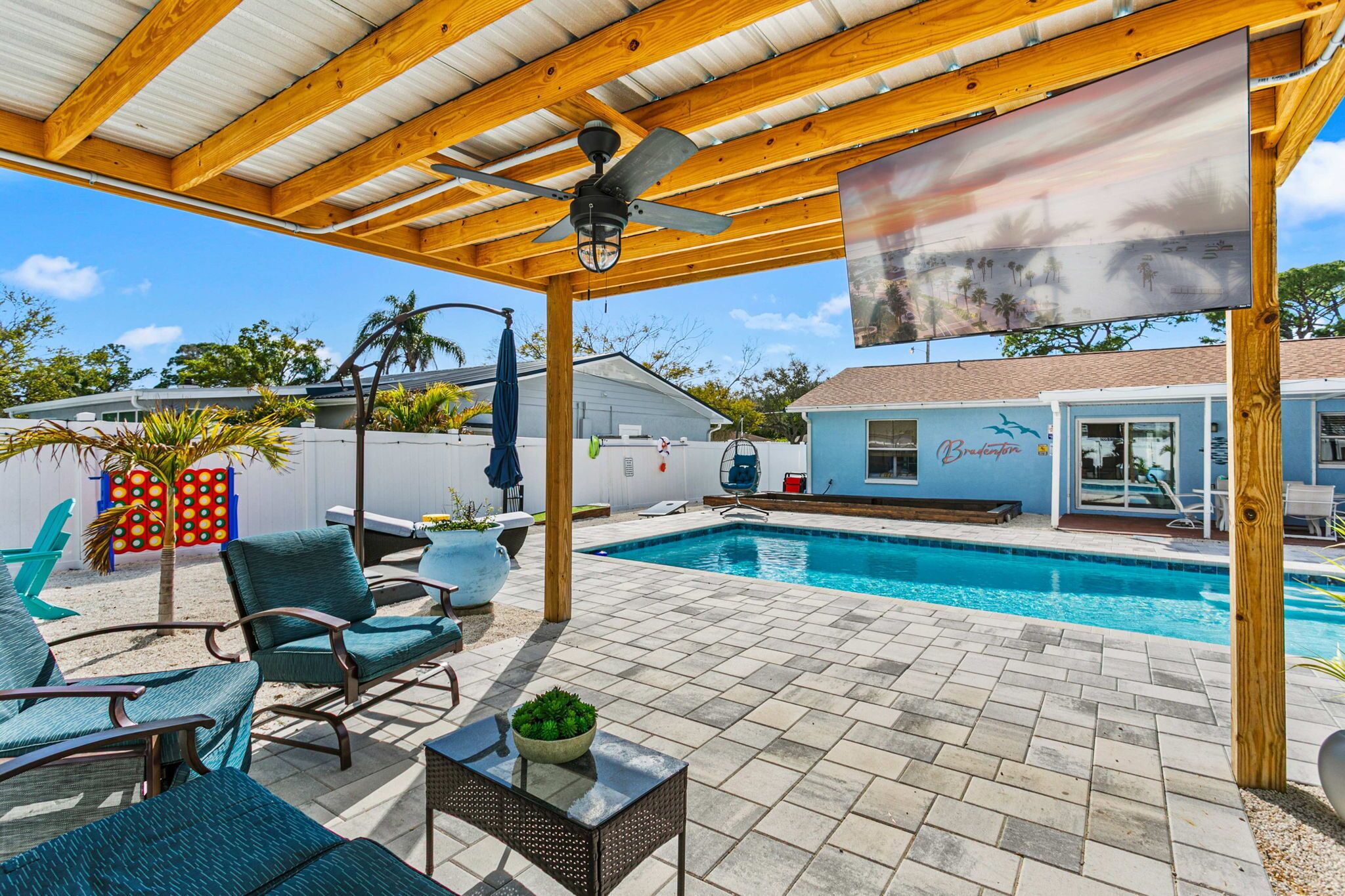 A covered outdoor area with a pool, lounge chairs, and a building labeled 'Brentwood.'