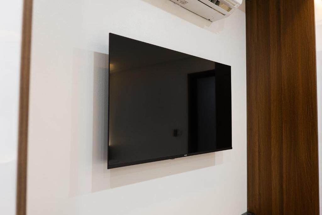 A flat-screen TV mounted on a white wall.