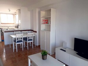 A compact living space with a kitchen, dining area, and a TV on a stand. - Apartment with sea and mountain views in the Playa Burriana area. Nerja (Nerja)