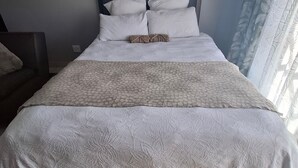 A bed with a headboard, pillows, and a blanket. - Serene 1-bedroom Apartment in Bloemfontein (Bloemfontein)