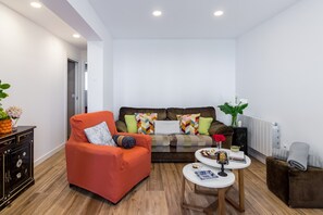A modern living room with a sofa, armchair, coffee table, and a cabinet. - Geno Apartment, Beachfront in Comillas (Comillas)