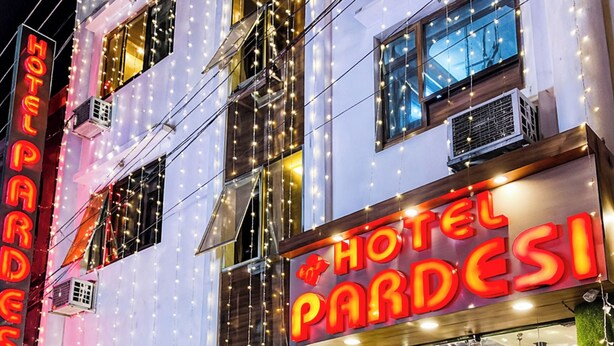 A hotel with a sign reading 'HOTEL PARDESI,' featuring a modern facade, a staircase leading to the entrance, and outdoor lighting. - Hotel Pardesi's Near Mansa Devi Temple (Haridwar)