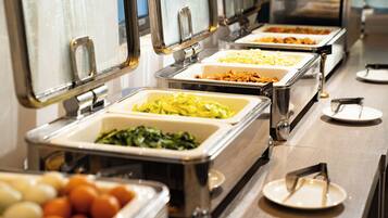 A buffet with various food items in metal serving trays.