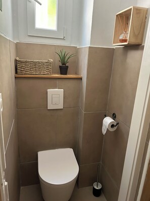 Een douche, handdoeken, zeep, toiletpapier