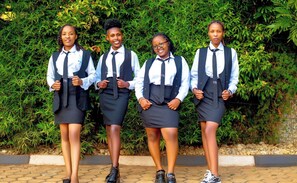 Four individuals in school uniforms standing in front of a green hedge. - Saint jean prestige hotel  (Kigali)