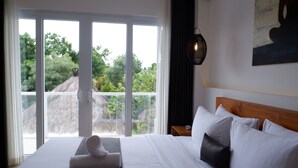 Una habitación de hotel con una cama grande, vistas por la ventana y un cuadro en la pared.