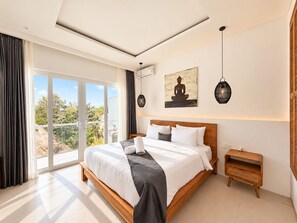 A modern bedroom with a large bed, a view of greenery outside, and a ceiling light fixture. - The Cosmos Villa - Balangan Pecatu Bali (Ungasan)