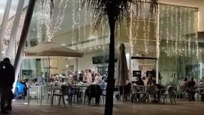 A modern indoor dining area with tables and chairs, a large umbrella, and string lights. - Relax & Play Panoramic Golf Vinaroz (Sant Jordi)