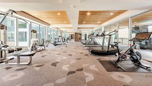 Une salle de sport équipée de machines de cardio, d’appareils de musculation et dotée d’un tapis à motifs.