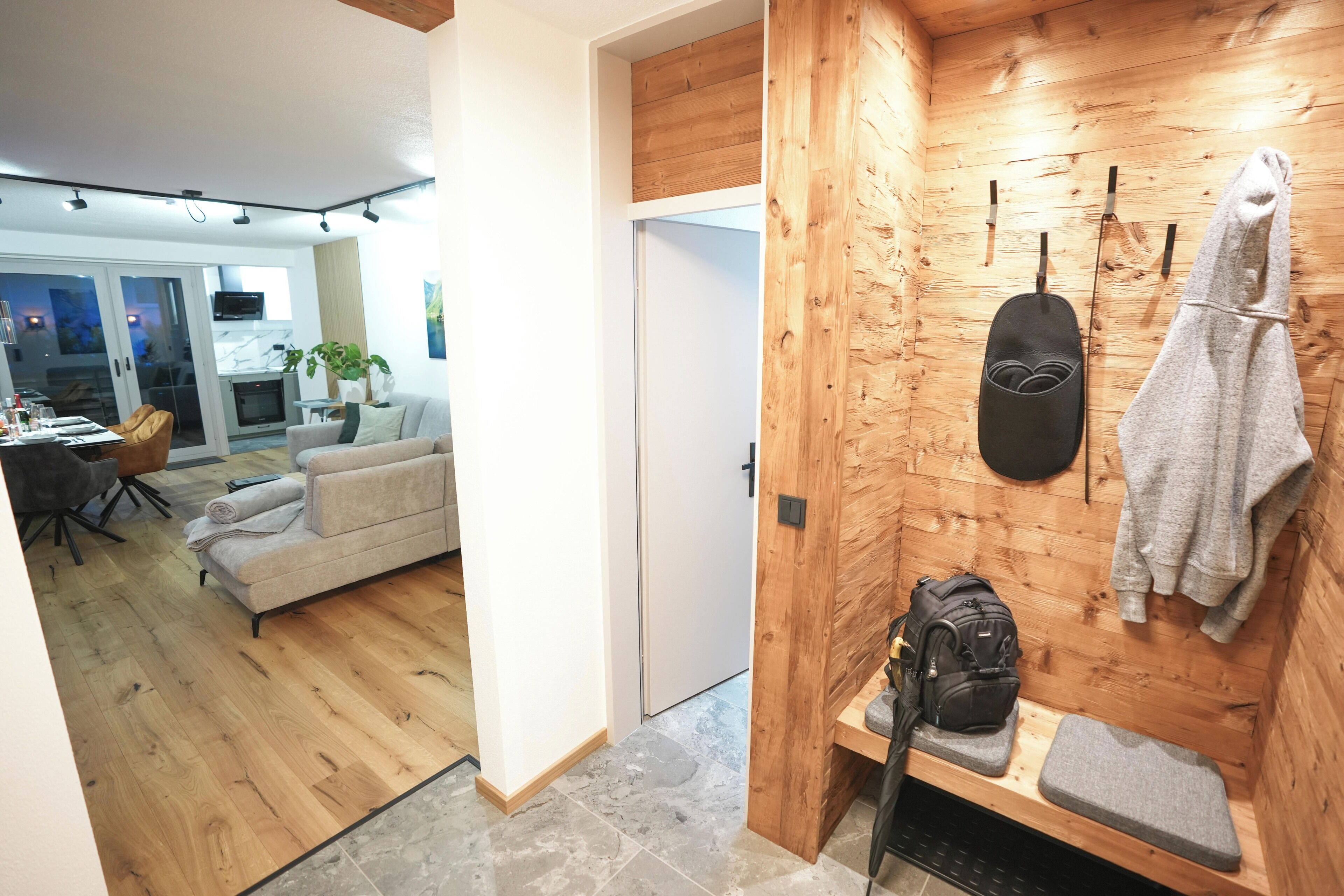 Un interior de madera con un sofá, un banco, una toalla y una mochila.