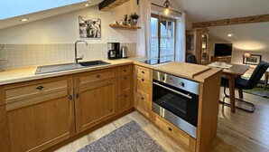 Eine moderne Küche mit Holzausstattung, integriertem Backofen und einem Oberlicht.