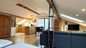 Ein Loft-Wohnraum mit Küche, Essbereich und einem großen Fenster.