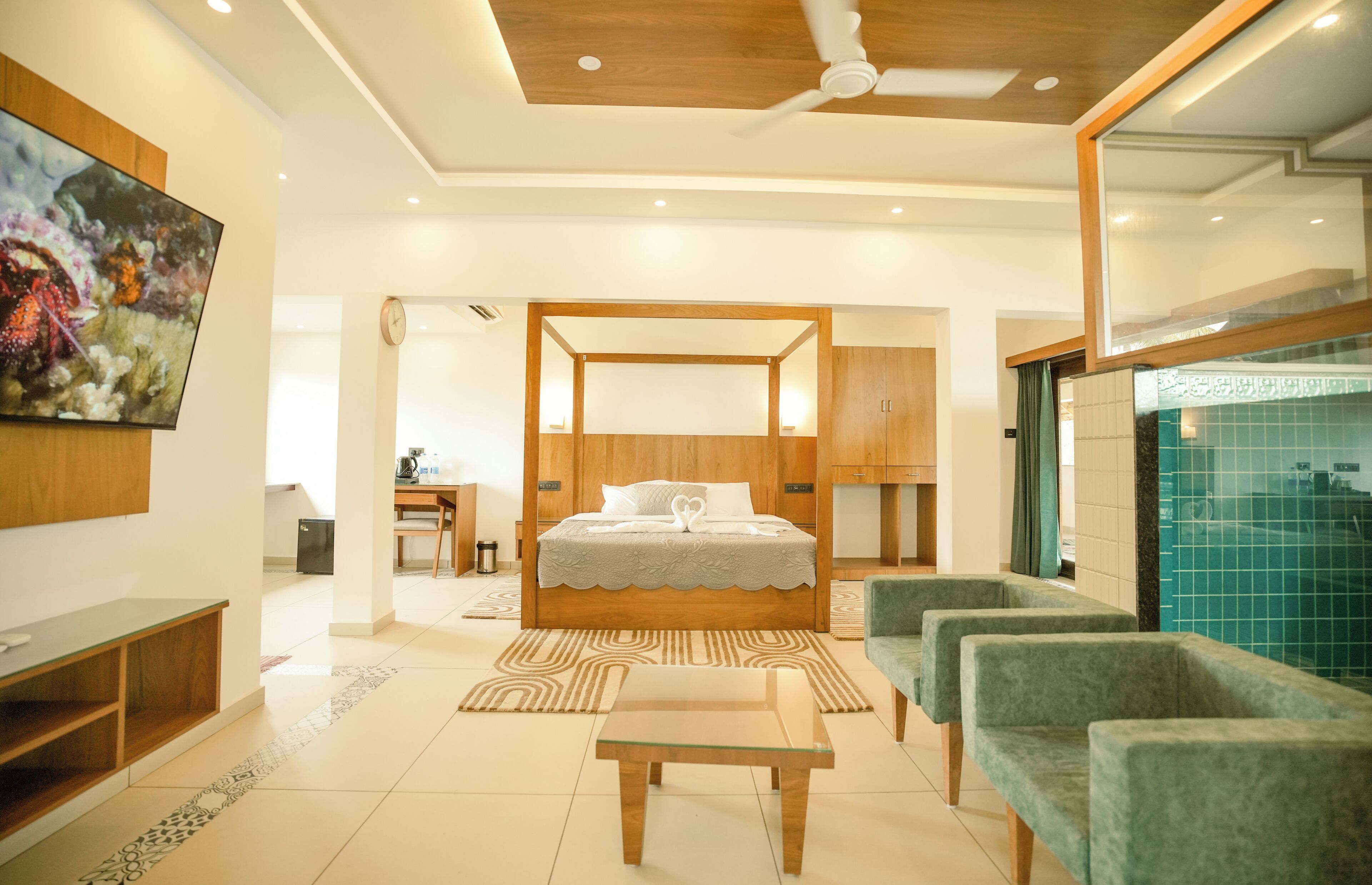 Una habitación de hotel moderna con una cama grande, televisión, escritorio y zona de estar.
