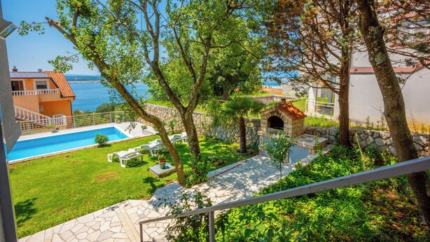A pool with lounge chairs, a stone pathway, and a view of the sea. - Vacation apartment with swimming pool, barbecue and sea view (Dramalj)
