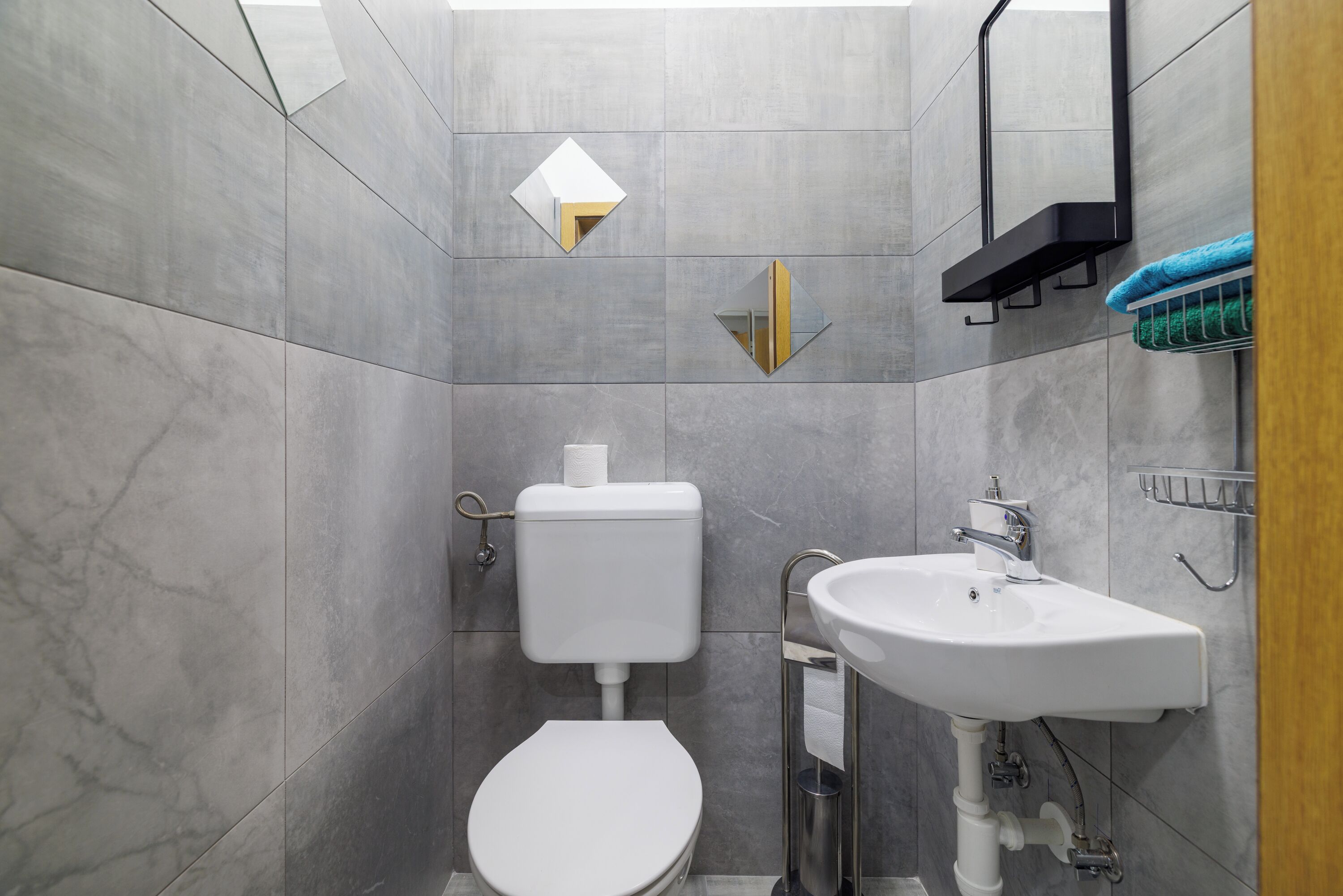 A modern bathroom with a toilet, sink, and mirror.