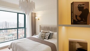 A hotel room with a large window, a bed with multiple pillows, a chandelier, and a wall-mounted book titled 'Aurora Folklore'. - 3-bedroom apartment with high-rise balcony Near Xintiandi CBD200m to  Metro. (Shanghai)
