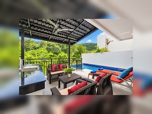 A covered outdoor area with a pool, seating, and a view of lush greenery. - Luxurious Villa with Private Pool and Stunning Views (ตำบล ฉลอง)