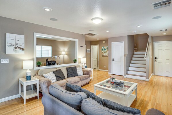 A living room with a sofa, coffee table, and a staircase. - 8 Mi to Strip! Poolside Desert Escape in Las Vegas (Las Vegas)