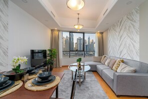 Ein modernes Wohnzimmer mit einer Couch, einem Esstisch und einem Fernseher.