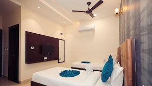 A hotel room with a bed, a ceiling fan, an air conditioning unit, and a mounted television. - HOTEL VANSHI VAT (Varanasi)