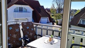 Eine Terrasse mit Tisch, Stühlen und Blick auf angrenzende Häuser.