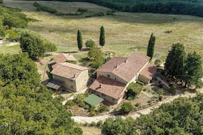 A stone building with a tiled roof, surrounded by trees and open fields. - Casa Stella Serena by Geco Vacation Rentals (Chiusdino)