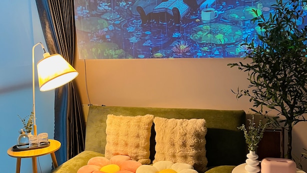 A room with a bed, a lamp, a small table, a plant, and a wall projection. - Trisstay Saigon - Dien Bien Phu (Ho Chi Minh City)