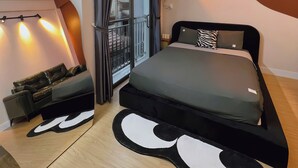 A modern bedroom with a bed, a sofa, and a view of the outside. - Trisstay Saigon - Dien Bien Phu (Ho Chi Minh City)