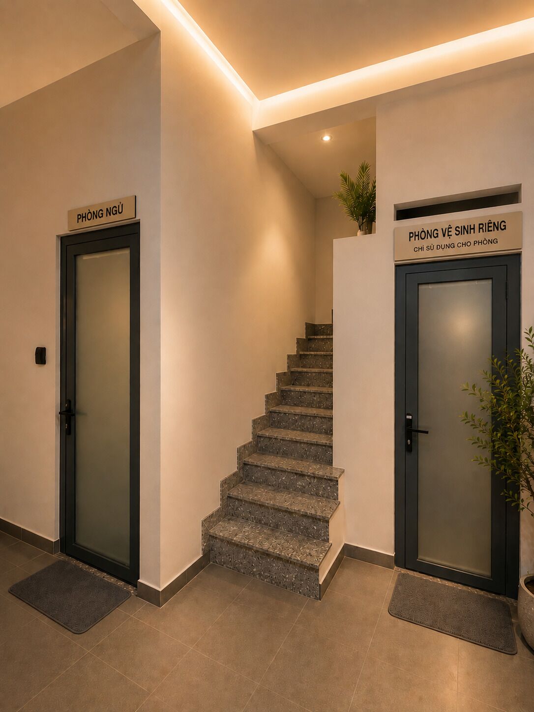 Un escalier avec deux portes, l’une portant l’inscription « PHÒNG NGƯ » et l’autre « PHÒNG VÊ SINH RIÊNG », menant à différents endroits.