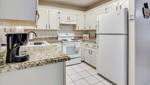 A kitchen with white cabinets, a stove, an oven, a refrigerator, and a coffee maker. - Pool Access & Work-Ready Comforts! Edinburg Apt (Edinburg)