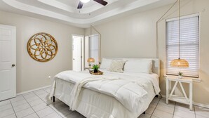 A bedroom with a bed, a ceiling fan, a wall-mounted lamp, and a door. - Pool Access & Work-Ready Comforts! Edinburg Apt (Edinburg)