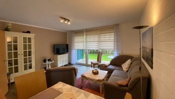 A living room with a sofa, a TV, a cabinet, and a table. - Appartmenthaus Nolting Apartment 2 Nolting with terrace & WLAN in Werdum - (Werdum)