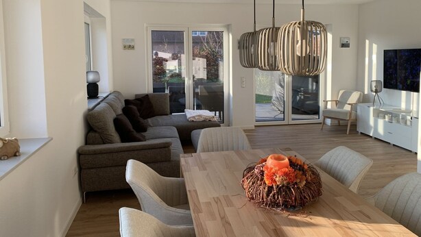 Un salon moderne avec un canapé, une table à manger et un élément décoratif central.