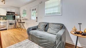 A modern kitchen with stainless steel appliances, a grey sofa with cushions, and a small round table with decorative items. - Couple’s Retreat! 7 Mi to Dtwn Atlanta & Six Flags (Atlanta)