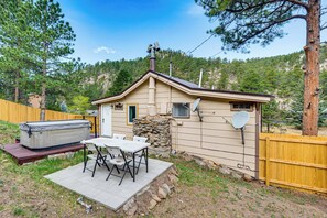 Ein kleines Haus mit Terrasse, Whirlpool und Satellitenschüssel.