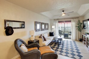 A living room with a sofa, chairs, a coffee table, a ceiling fan, a large mirror, and a checkered floor. - Boutique-Style Condo, Just Outside Overland Park (Louisburg)