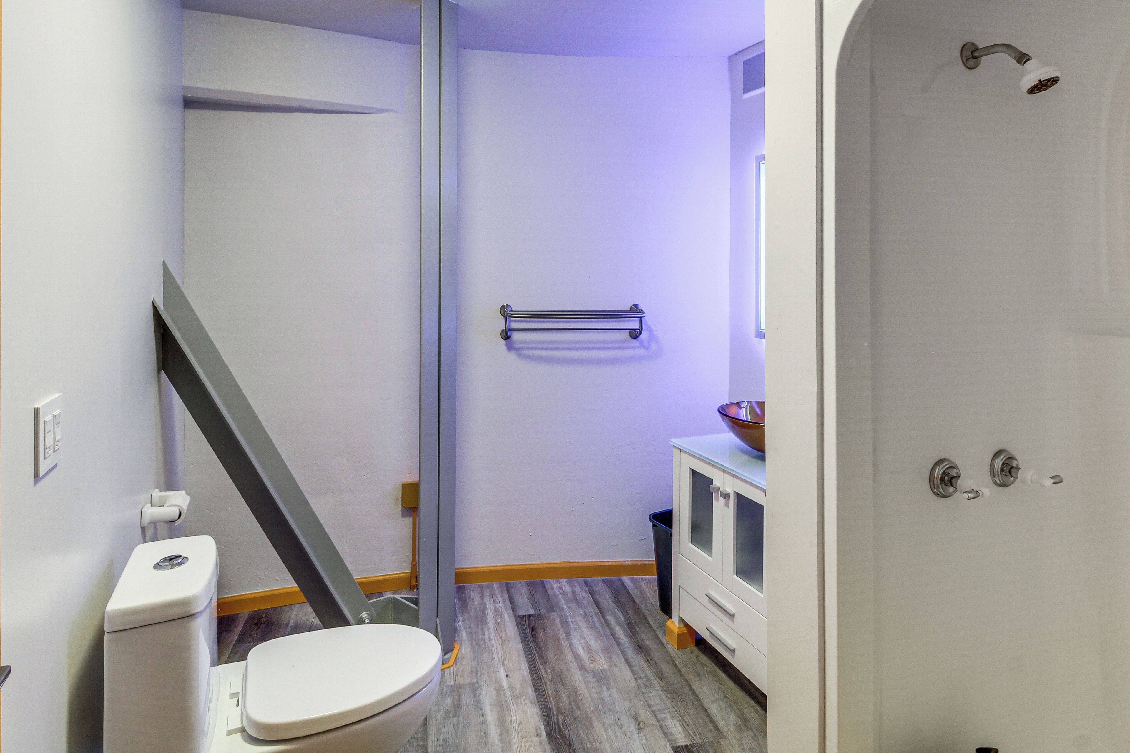 A bathroom with a toilet, a shower, a sink, and a towel rack.