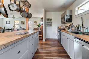 A kitchen with wooden countertops, stainless steel appliances, and a hanging pot rack. - Group Friendly! Mtn-View Haven in Waterbury Center (Waterbury Center)