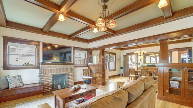 A spacious living room with a fireplace, wooden beams, a large sofa, and a dining area. - 3 Blocks to Plaza! Historic Prescott Gem w/ Grill (Prescott)