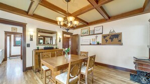 A dining area with a wooden table and chairs, a chandelier, and framed pictures on the wall. - 3 Blocks to Plaza! Historic Prescott Gem w/ Grill (Prescott)