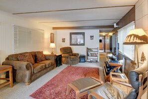 A living room with a sofa, armchair, ottoman, coffee table, and a TV. - 'Elk Home' - Yellowstone Basecamp < 1 Mi to Park! (West Yellowstone)