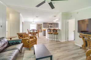 A living room with a sofa, chairs, a coffee table, a TV, and a kitchen in the background. - Near Rocket Launches & Beaches! Cocoa Family Home (Cocoa)