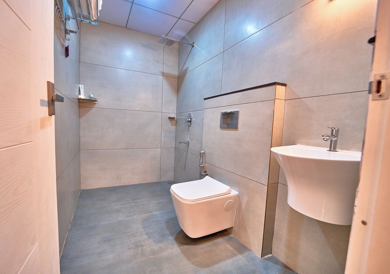 Een moderne badkamer met toilet, wastafel en douche.